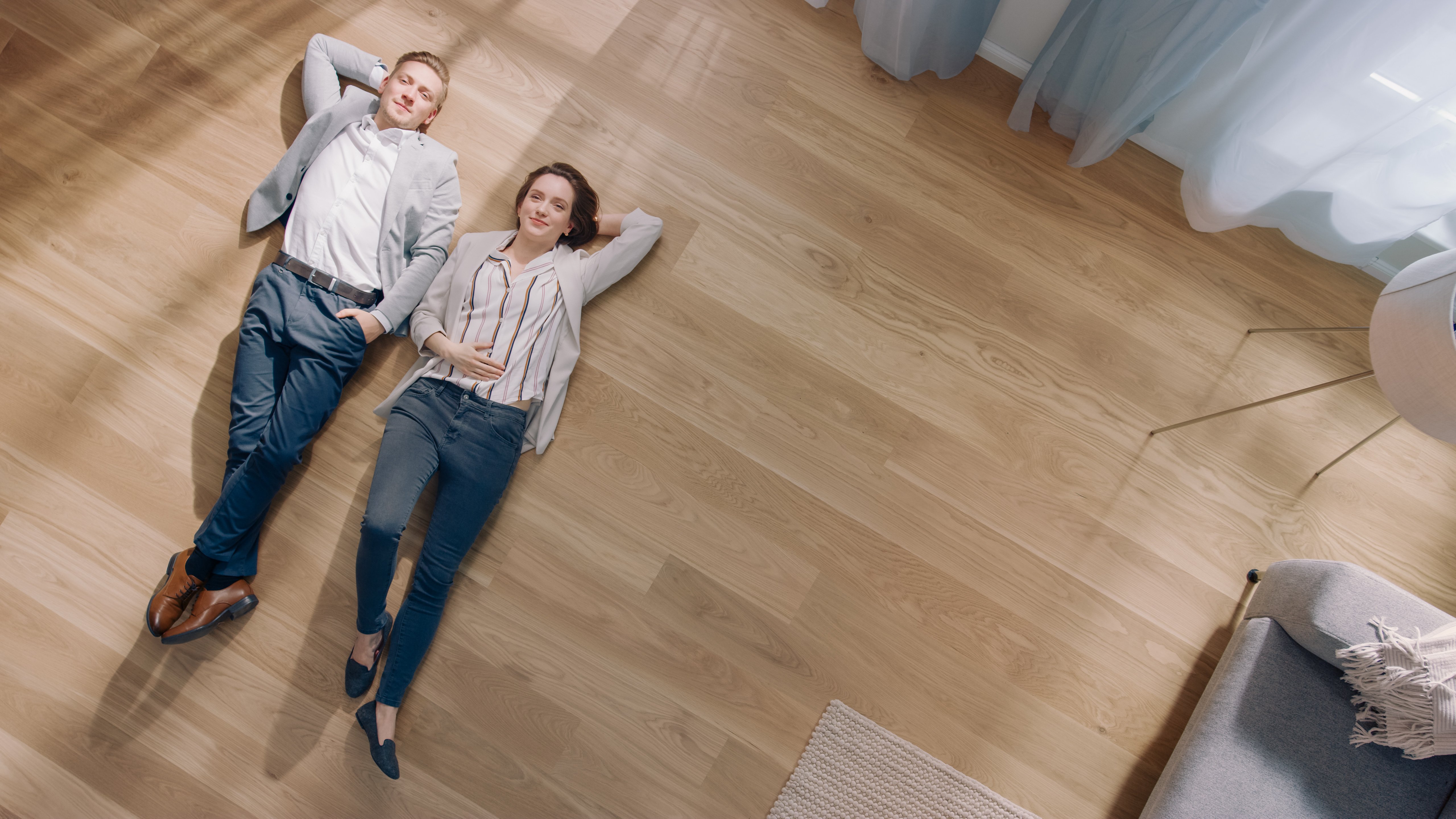 young couple laying on empty floor